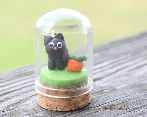 Black cat and tiny pumpkin in tiny cloche